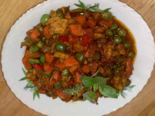 Diced Carrots and Peas with fresh basil leaves